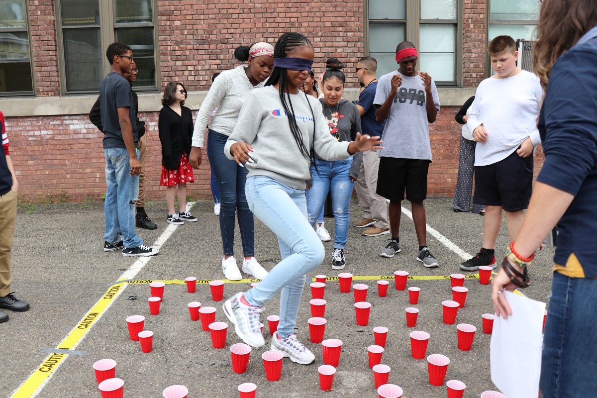 Students help each other navigate maze.