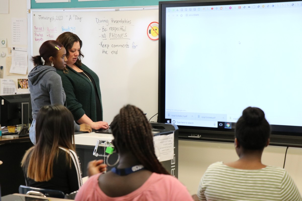 ITF Mrs. Holmes works with scholar to set up her presentation.