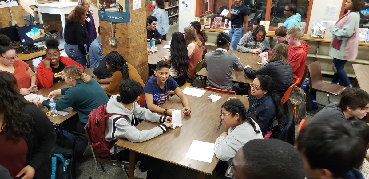 Students work together with IBM volunteers on a project.