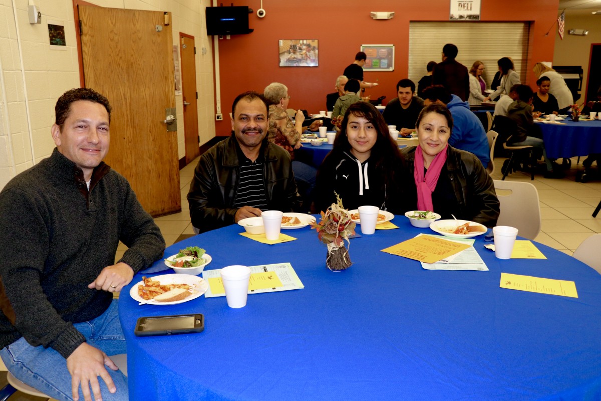 Family sits with Board member, Mr. Stridiron and enjoys Pasta with the Principal