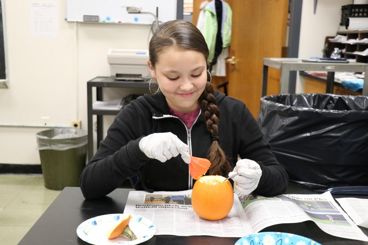 Student dissecting a pumpkin.