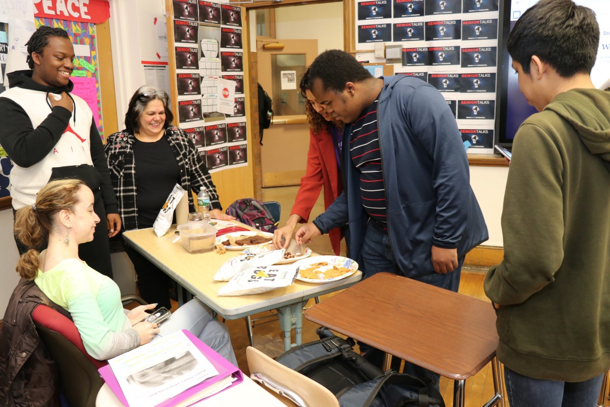 Students inspecting and trying the foods.