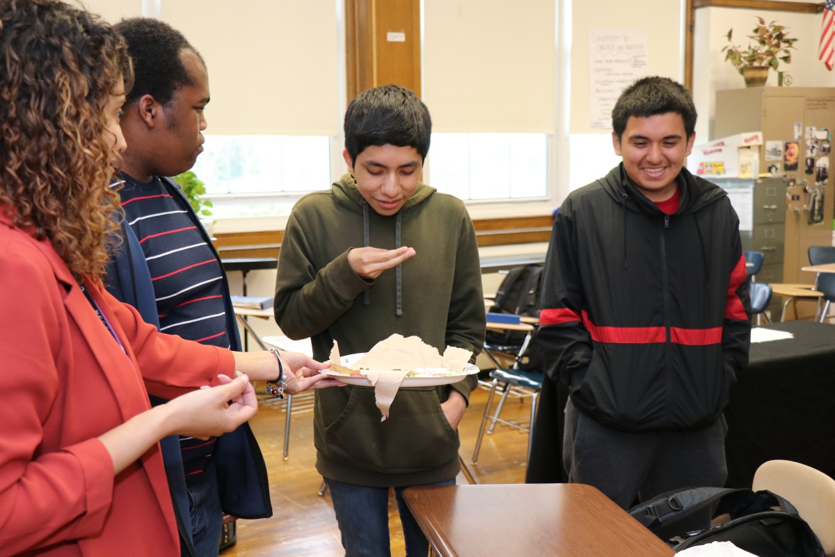 Students inspecting and trying the foods.