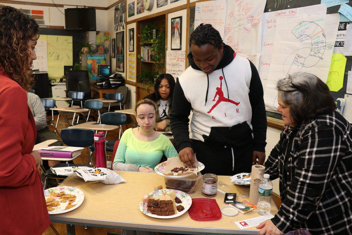 Students inspecting and trying the foods.