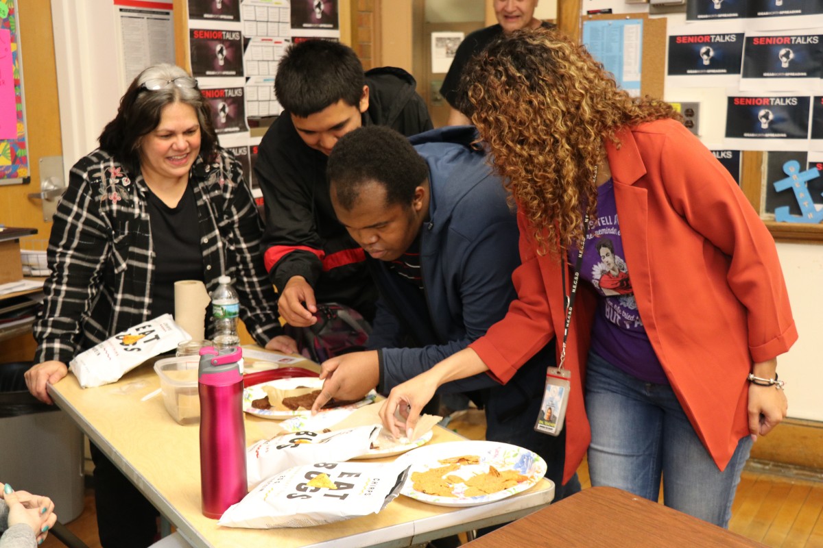 Students inspecting and trying the foods.