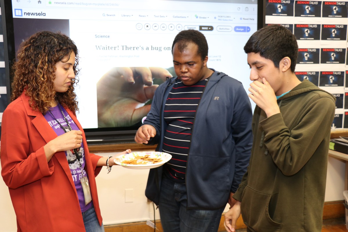 Students inspecting and trying the foods.