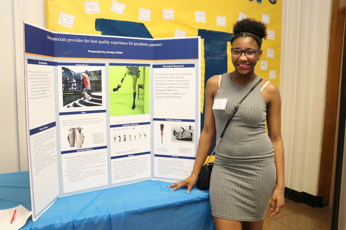 Student stands by post presentation.