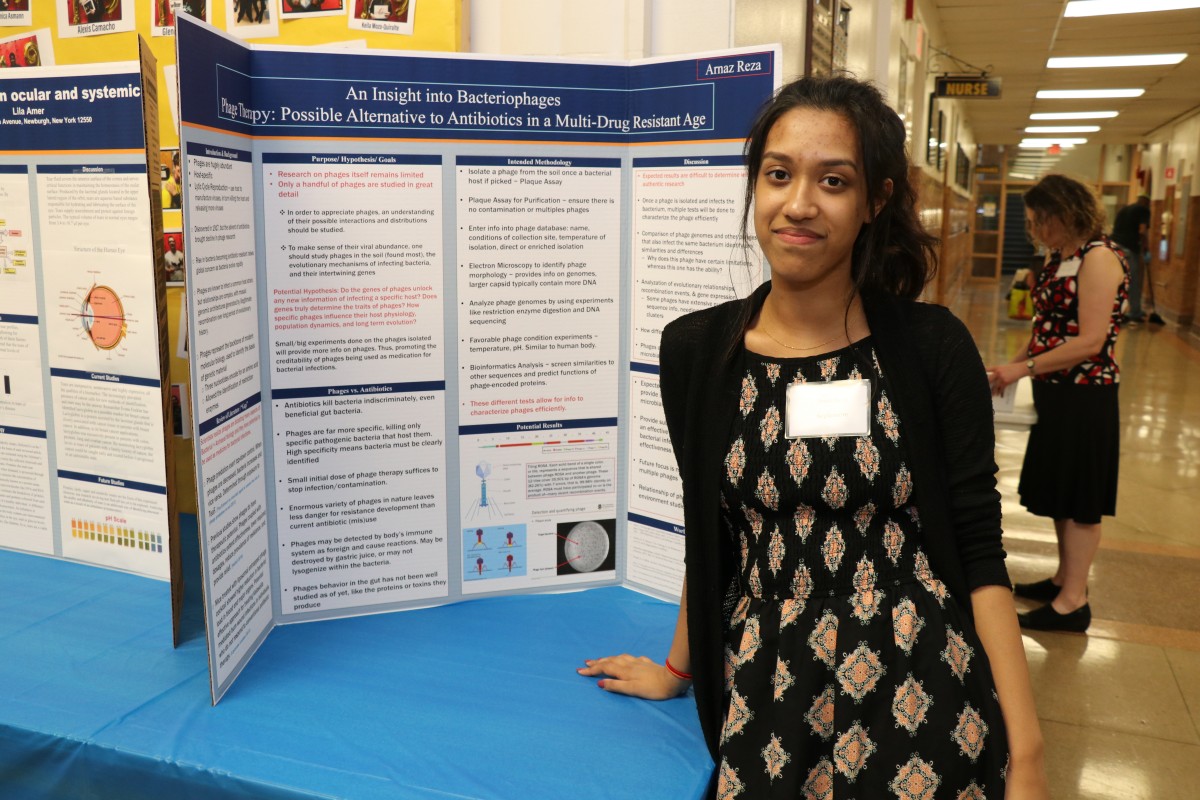 Student stands by post presentation.