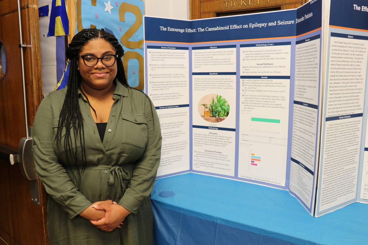 Student stands by post presentation.