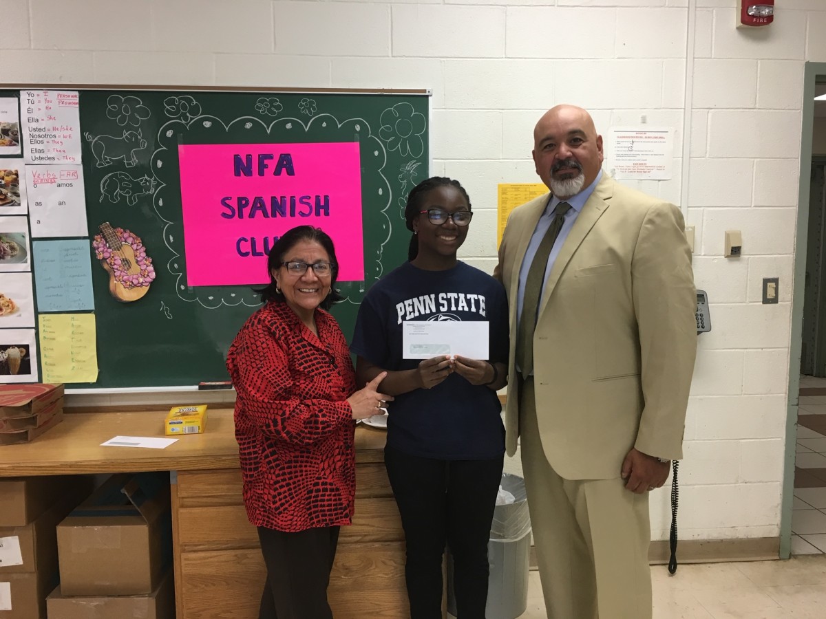 Award recipient from Spanish Club stand with club advisor Mrs. Kennedy and co-principal of NFA Main, Mr. Raul Rodriguez.