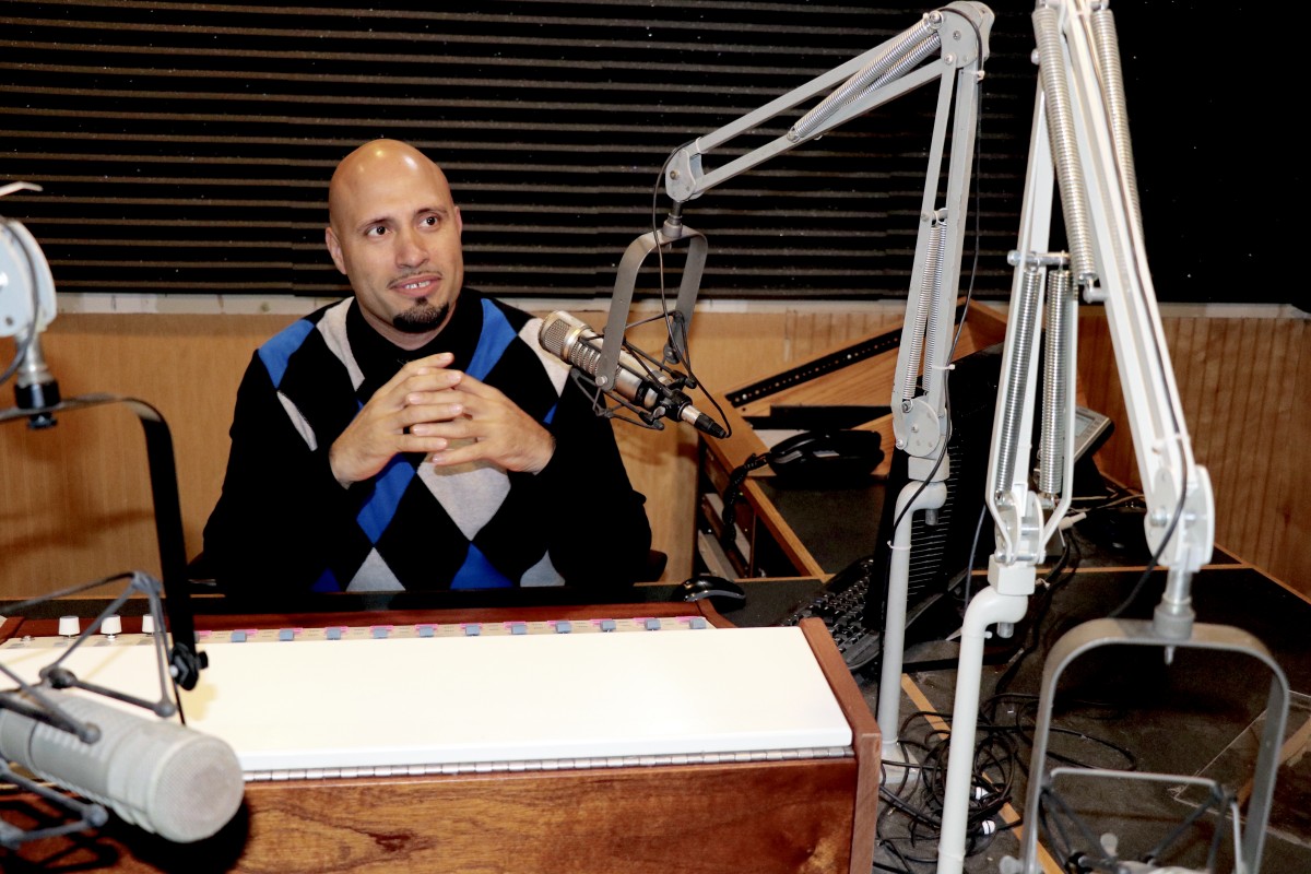 Dr. Padilla poses at radio microphone