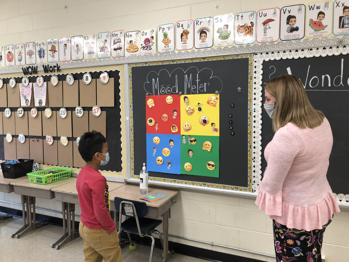 Ms. Santana works with a student to learn how to use the Mood Meter.