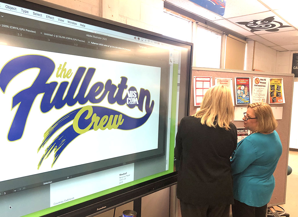 Ms. Patsalos and Ms. LeRoy look at finished posters.