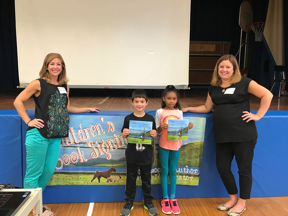 Author and Illustrator with students holding their books