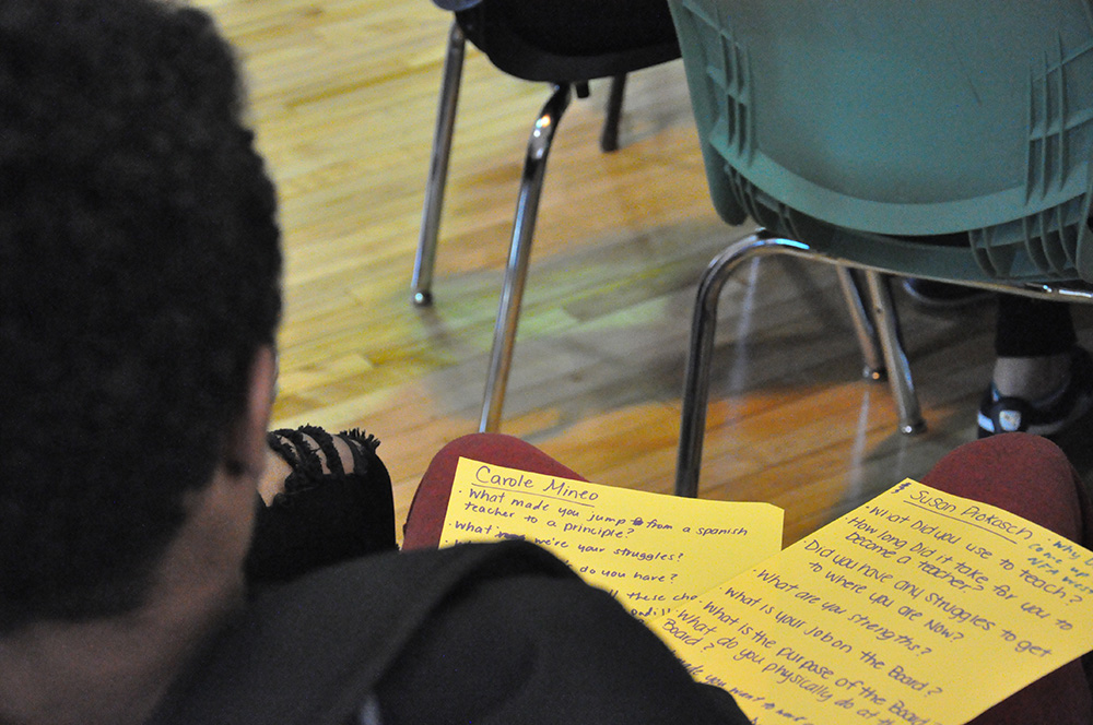 A student takes notes during the presentation.