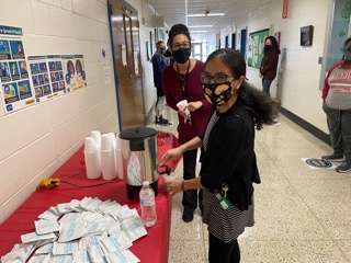 Faculty/staff selecting their sticker and picking up a treat.