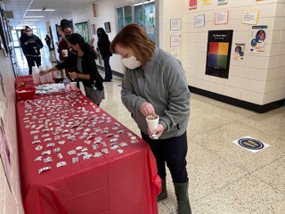 Faculty/staff selecting their sticker and picking up a treat.