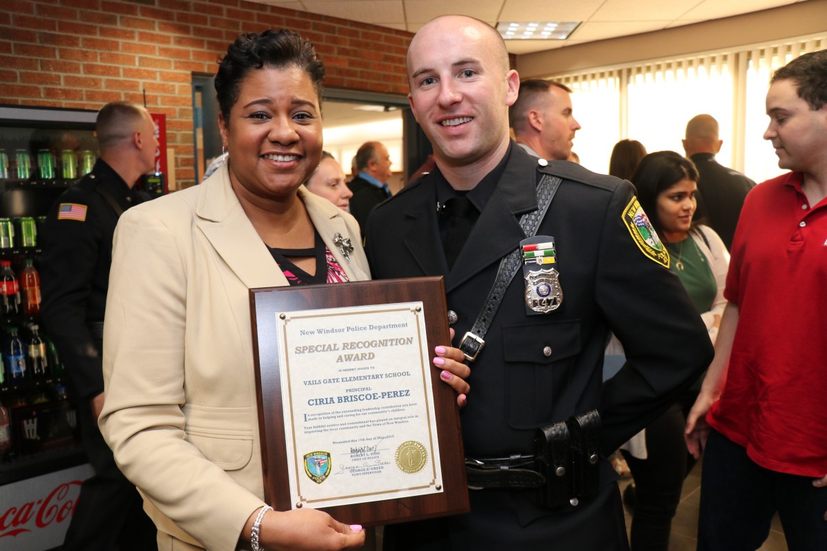 Mrs. Briscoe-Perez poses with officer and her award.