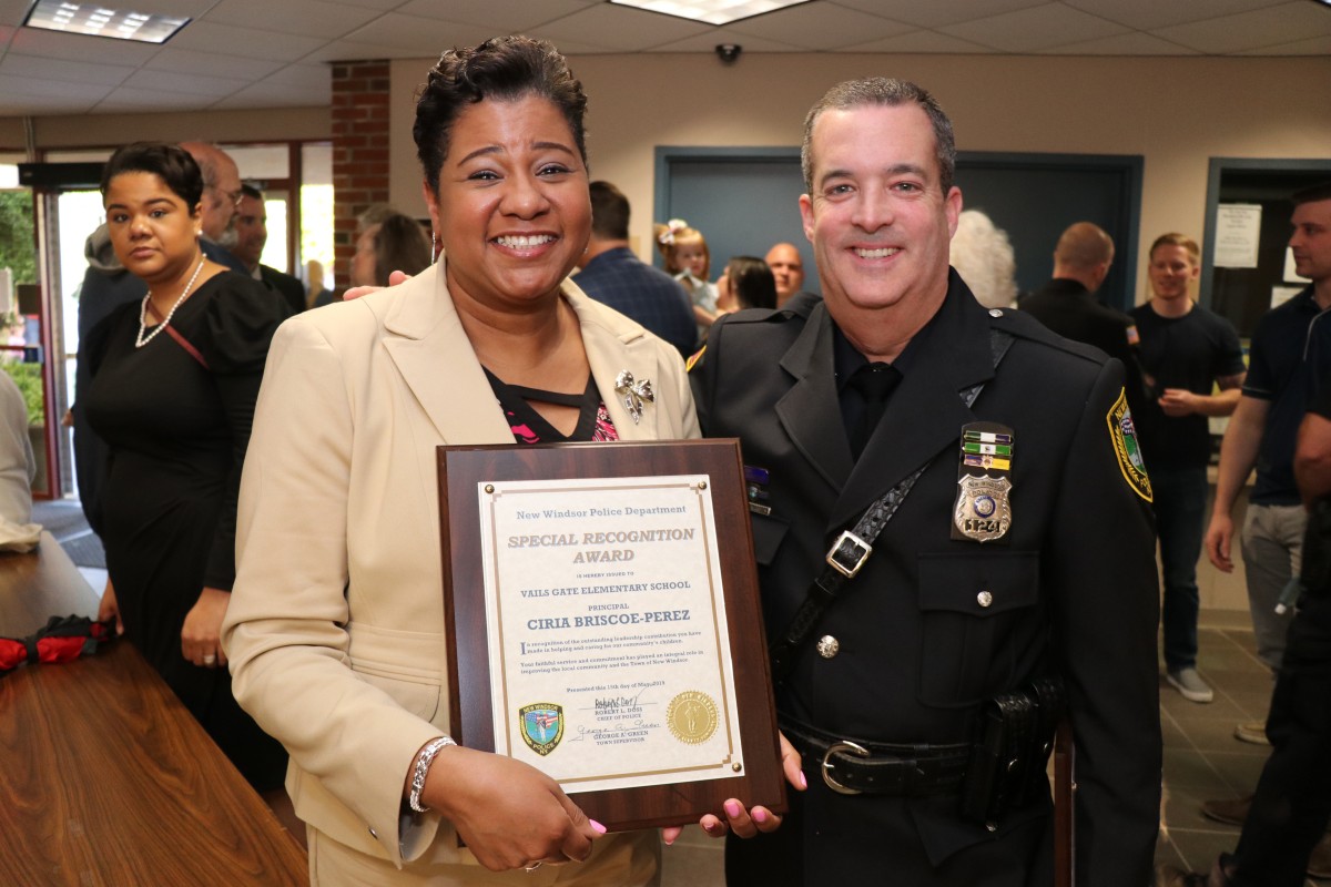 Mrs. Briscoe-Perez poses with officer and her award.