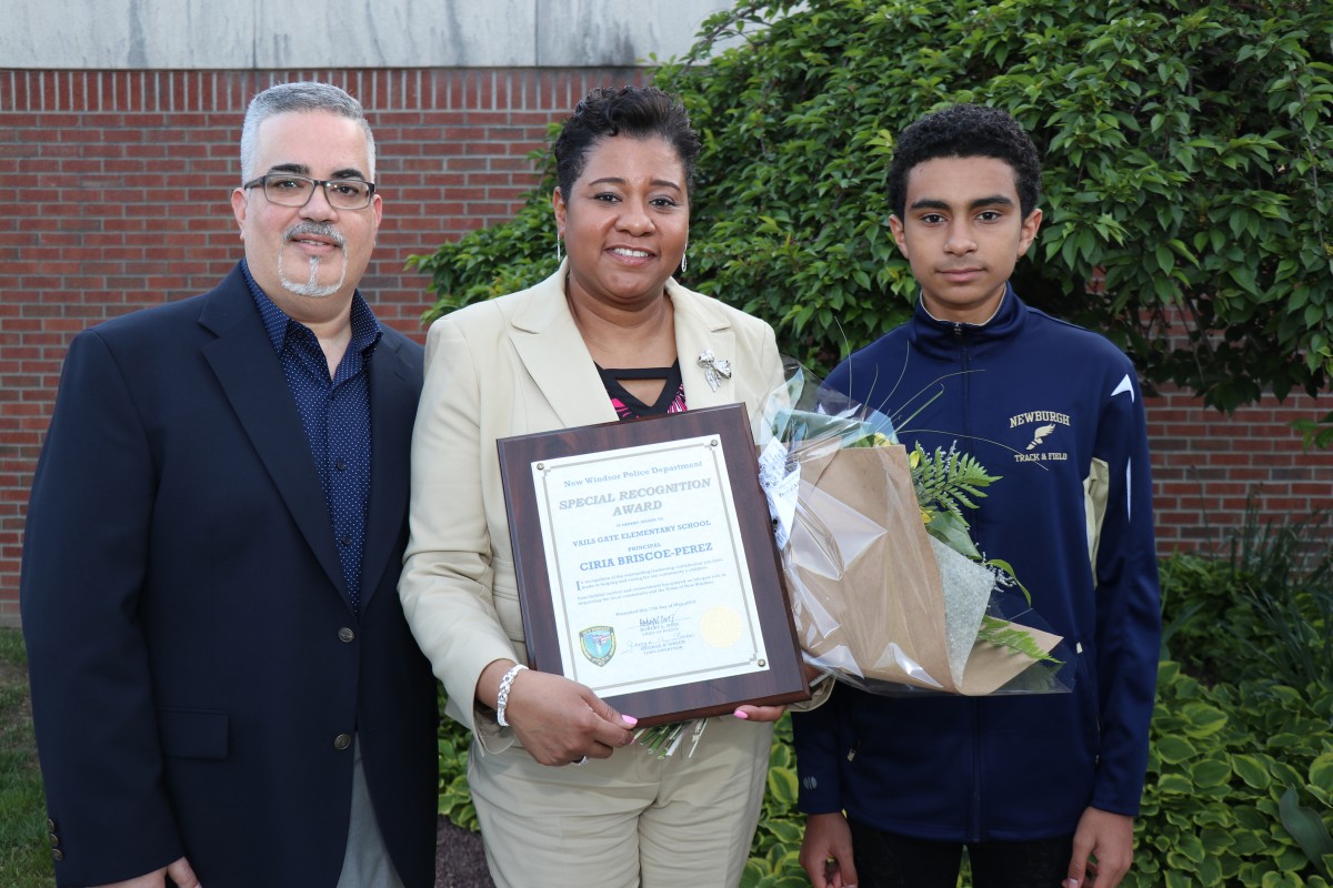 Mrs. Briscoe-Perez poses with family and her award.