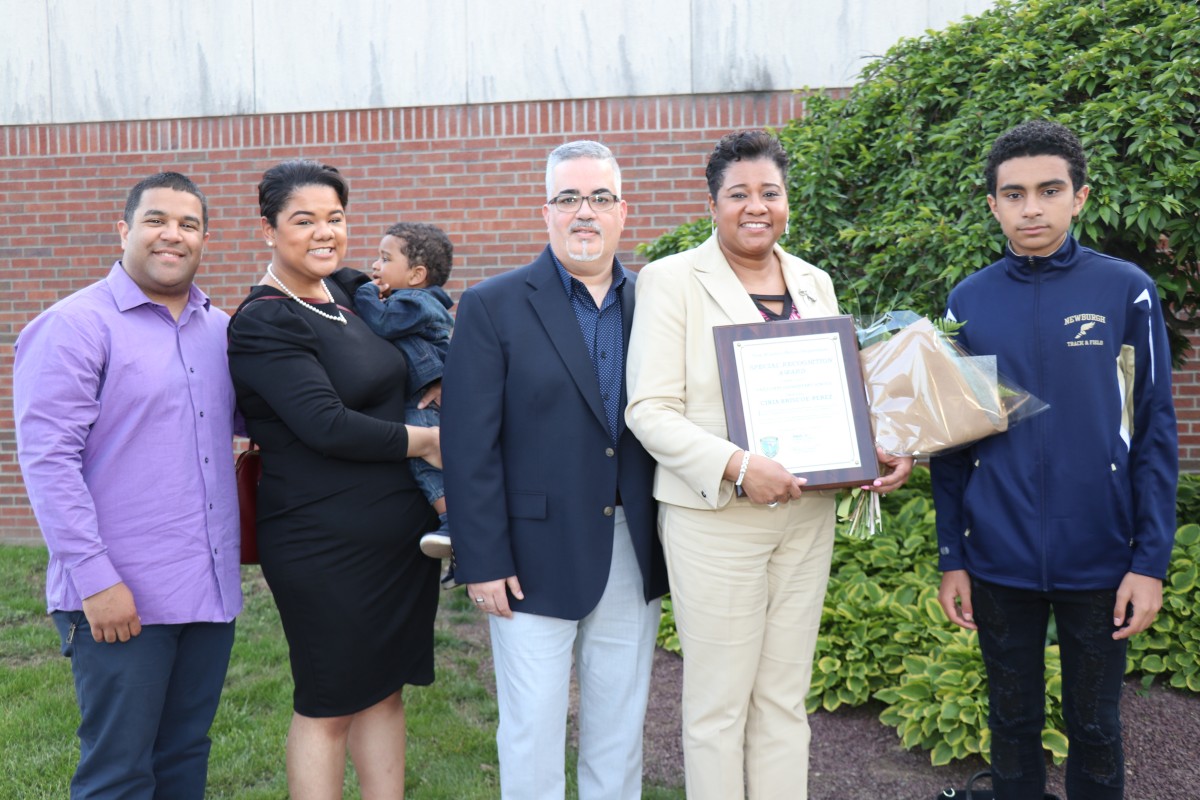 Mrs. Briscoe-Perez poses with family and her award.